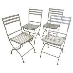 Set of four white finish wrought metal strapwork folding garden chairs