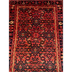 Persian red ground runner, the field decorated with repeating floral design Herati motifs, the main indigo ground border decorated with stylised flowerheads, framed within guard stripes