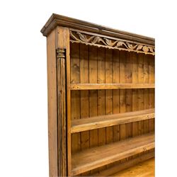 Traditional pine dresser, projecting cornice over pierced foliate frieze, the three-tier plate rack flanked by reeded pilasters, breakfront base fitted with four central drawers with arch panelled cupboards to either side, raised on bracket feet