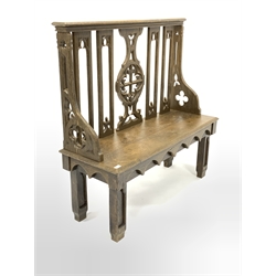 19th century oak hall bench of Gothic design, with arched splats carved with fleur de lis, chamfered panel seat, raised on carved block supports 