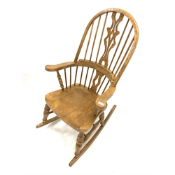 20th century elm Windsor style rocking armchair, hoop back with spindles and pierced splat over saddle seat and turned supports united by double 'H' stretcher, W65cm