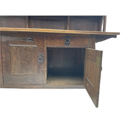 Attributed to Leonard Francis Wyburd for Liberty & Co. - Arts & Crafts  period oak dresser, raised back with shelves either side of cupboard enclosed by lead glazed door, the splayed angular base fitted with single drawer and two cupboards