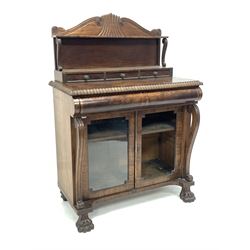 Irish Regency mahogany chiffonier, the raised back with scroll and lobe carved arched pediment and open shelf and three drawers, over gadroon carved top and cushion fronted drawer, two glazed doors enclosing shelf, flanked by 's' scroll pilasters, raised on paw front supports 