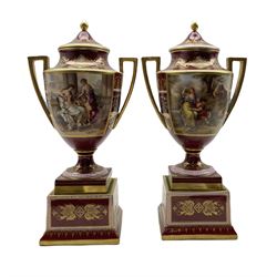 Pair of Vienna style two-handled vases and covers, each reserved with a panel painted by K. Weh with either 'Schmukung der Venus' or 'Rinaldo and Armida', the reverse painted with classical figures against claret, pink and gilt heightened ground, raised on square bases, beehive mark in blue, script titles in black H37.5cm 