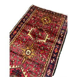 Persian Karajeh runner, red ground with nine geometric medallions, the field decorated all-over with small stylised plant, animal and bird motifs, the border decorated with geometric star motifs