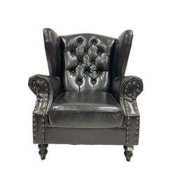 Georgian style wingback armchair, upholstered in buttoned black fabric with stud work, turned front feet