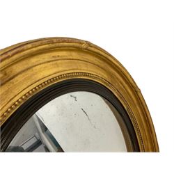 Regency giltwood framed circular wall mirror, the convex frame in reeded mahogany slip, frame decorated with beaded moulded and ribbon twists