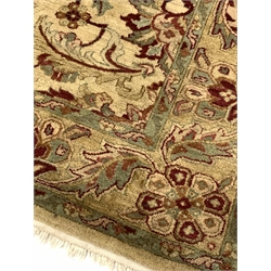 Fawn ground thick pile wool rug, the central field decorated with floral design of yellows, greens and reds, further stylised foliate to border 