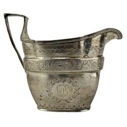 George III silver cream jug with engraved decoration and angular handle London 1804 and a George IV silver fiddle pattern sifting spoon London 1823 Maker Thomas Wilkes Barker (2)
