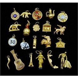 Twenty one 18ct gold charms including guitar, gaming wheel, lion, Eifel tower, Romulus and Remus, all stamped or tested, approx 23.9gm