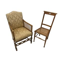 Early 20th century beech framed bergere armchair, shaped back with cane arm supports, sprung seat and back upholstered in ivory damask fabric, on turned supports with flower head carved front stretcher (W53cm H89cm); Early 20th century hall chair, high back over cane seat (W39cm H91cm)