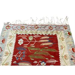 Turkish Kilim ivory and crimson ground rug, the field decorated with wheat ear design and stylised flower heads, the pale indigo and ivory borders with trailing tulip patterns, with raised braiding 