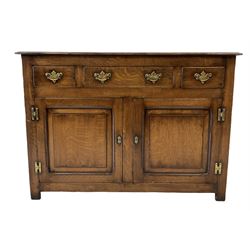 Oak sideboard, the projecting rectangular top over one long and two short drawers over two cupboard doors opening to reveal one adjustable shelf, raised on stile supports 