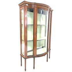 Edwardian inlaid mahogany serpentine display cabinet, glazed door enclosing two shelves, raised on square tapered supports with peg feet W107cm, H16cm, D47cm 