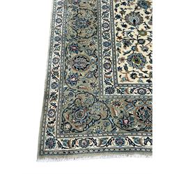 Persian Kashan ivory ground rug, the field with overall floral design decorated with stylised flower head motifs and interlacing branch, scrolling border decorated with repeating plant motifs