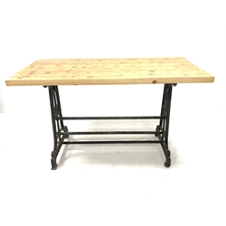 19th century industrial cast iron table, scrolled end supports united by three stretchers stamped 'The Crown', one side raised on castors, with a later solid pine top, 134cm x 70cm, H80cm