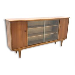 Mid century teak bookcase, two central sliding glass doors enclosing two adjustable shelves, cupboard to each end enclosing more shelves, raised on square tapered supports W165cm, H210cm, D63cm