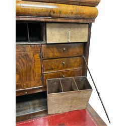 Early 18th century walnut escritoire, the projecting moulded cornice over a cushion frieze drawer, the banded fall-front with concentric feather stringing and inset red leather writing surface to the interior, enclosing a fitted interior comprising nine pigeonholes concealing three secret drawers over an assortment of eleven small drawers surrounding a central cupboard, the base with two short over two long feather-strung graduating drawers on later bracket feet
Provenance: From the Estate of the late Dowager Lady St Oswald