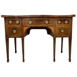 George III inlaid mahogany serpentine sideboard, the shaped top with banded edge, fitted with central frieze drawer flanked by two graduating drawers and a double drawer, each with cross-banded and boxwood strung facias, the circular pressed brass plates in rosette form with ring handles, the spandrels inlaid with satinwood and ebony in an extending floral pattern, raised on square tapering supports terminating in spade feet