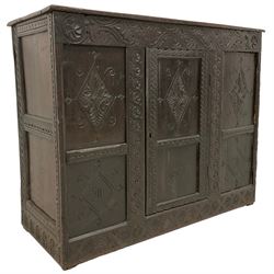 17th century and later carved oak cupboard, rectangular top with moulded edge over a frieze carved with s-scrolls and palmette motifs, the panelled front carved with foliate lozenges and engraved with Jacobean 'J I' and '1629' lettering, flanked by uprights carved with interlocking guilloche patterns, fitted with single panelled door enclosing shelf, on skirted base