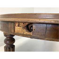 Late Victorian mahogany extending dining table, with 'D' shaped moulded ends and three additional leaves, raised on turned and reeded supports terminating in brass cup castors
