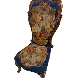 19th century walnut nursing chair, the high back carved with scrolling acanthus leaves, the seat and back upholstered in floral needlework, on cartouche carved cabriole supports with scrolling terminals