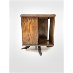 Early 20th century oak revolving bookcase, moulded top over four book recesses, raised on swivel cruciform base, bearing paper label underneath 