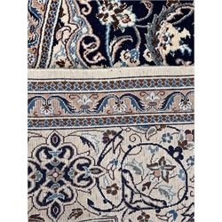 Persian Nain ivory ground rug, shaped blue ground field decorated with medallion and surrounded by interlaced foliate and stylised flower head motifs, repeating border in scrolling design, with silk inlay 

