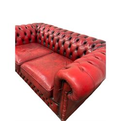Chesterfield two seater sofa, the buttoned back and arms and two squab cushions upholstered in red fabric 