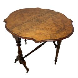 Late 19th century walnut Sutherland table, shaped bookmatched veneer drop-leaf top, raised on two vasiform turned column with splayed scrolled cabriole supports on brass castors, united by turned stretcher, the gate-leg supports turned and tapered terminating in brass castors