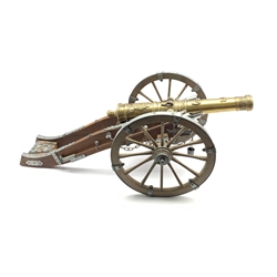 Model of a Louis XIV canon, metal mounted wood carriage with rotating wheels and embossed brass barrel, L77cm