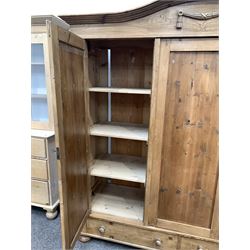 Late 19th century Continental pine triple wardrobe, arched cornice with applied carved swag decoration, three panelled doors enclosing shelves and interior fitted for hanging, two drawers under, raised on compressed bun supports W193cm, H204cm, D61cm