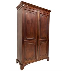 George III design mahogany double wardrobe, projecting cornice and banded frieze, two panelled doors enclosing hanging rail, on bracket feet