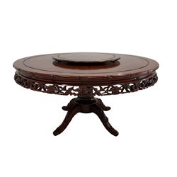 Circular rosewood dining table over one turned pillar leading into four splayed supports, together with lazy Susan and eight chairs with loose cushions