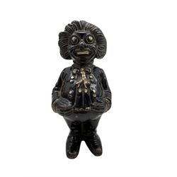 Cast Iron Golly money box H16cm.

Originally handmade by mothers in Africa for their children from old fabric and cloth, the golly doll was adopted as the mascot and trademark for the Robertson's confectionery brand around 1910 after the company's founder John Robertson visited the US and noticed children playing with them. Robertson's Gollies have been collected by people across the UK and around the world for generations but garnered a contentious image in the 1980s because of links to racism. The trademark was removed from Robertson's branding in 2001. 