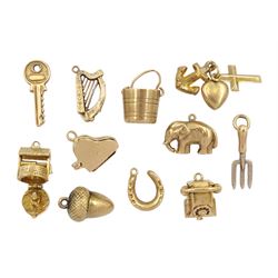 Eleven 9ct gold charms including gardening fork, piano, wishing well, elephant, acorn, key and telephone