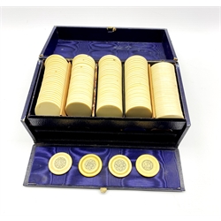 Edwardian blue leather games box containing four Victorian ivory gaming counters each silver inlaid with the number 5 and monogram to the reverse, together with two trays of ivorine and plastic gaming counters, L23cm 