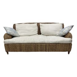 20th century two seat woven seagrass sofa, Howard shape with downswept arms, with cream upholstered loose seat and back cushions, on turned feet