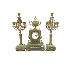 Late 19th century onyx and gilt three-piece clock garniture, the clock case surmounted by an urn shaped finial, over a white enamel dial with Arabic chapter ring, eight day movement striking the hours hammer on bell 