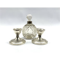 Edwardian silver mounted cut glass scent bottle of globular form H14cm and a pair of Sterling silver dwarf candlesticks (3)