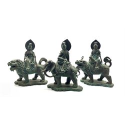 Three Chinese patinated bronze figures modelled as a Deity seated on the back of an Elephant and two similar models seated on a Dog of Fo, H39cm (3)