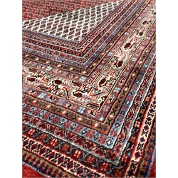 Large Persian Araak carpet, red ground field decorated all over with Boteh motifs, multiple band border, 420cm x 319cm
