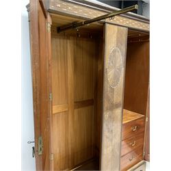Early 20th century veneered double wardrobe, projecting cornice over frieze with inlaid mother of pearl decoration, two doors enclosing interior fitted with 'Everitt's patent' hanging system and three drawers, the doors with radial cut veneers, raised on shaped plinth base W150cm, H211cm, D49cm