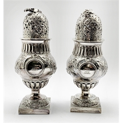 Pair of vase shape silver sugar casters, the two cartouches engraved with a crest and monogram, embossed with trailing flowers and with floral finials on square bases H19cm Sheffield 1903/4 Maker James Dixon & Sons 19oz