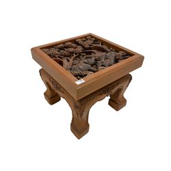 Hardwood occasional table, the square top carved with elephants and trees in a wild landscape, the shaped apron carved with extending foliate decoration, raised on cabriole supports
