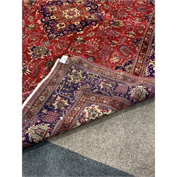  Large Persian fine Tabriz red ground carpet, central medallion on busy red field, with stylised foliate to multi line border, 406cm x 304cm