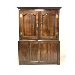 18th century oak press, projecting cornice over two panelled doors with brass fixtures, four panelled base raised on stile supports, the interior converted for hanging W137cm, H187cm, D52cm
