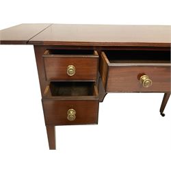 Regency mahogany drop-leaf side table, rectangular top with reeded edge supported by pull-out stays, fitted with central frieze drawer flanked by four small drawers, each with ebony cock-beaded facias and Sheraton design brass knobs, raised on square tapering supports with brass cups and castors