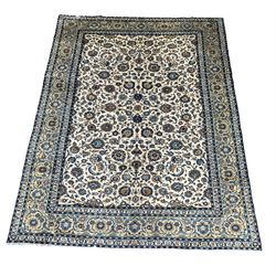 Large Persian Kashan ivory ground carpet, the central field decorated with repeating interlaced floral motifs, enclosed by border with similar decoration 298cm x 410cm