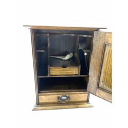Early 20th Century oak smokers cabinet of Art Nouveau design with lifting top, fitted interior and single door with copper insert and single drawer under containing clay and other pipes 40cm x 32cm